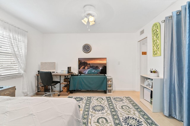 tiled bedroom featuring ceiling fan