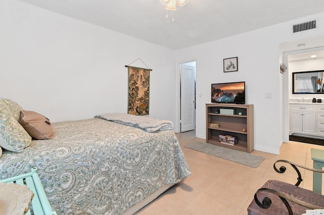 bedroom featuring light tile patterned flooring, connected bathroom, and sink