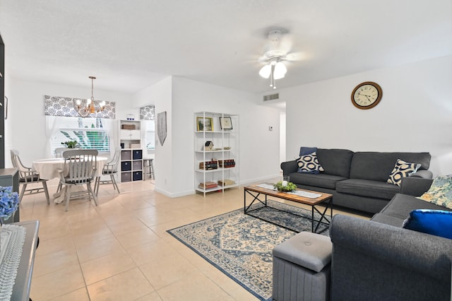 tiled living room with ceiling fan with notable chandelier