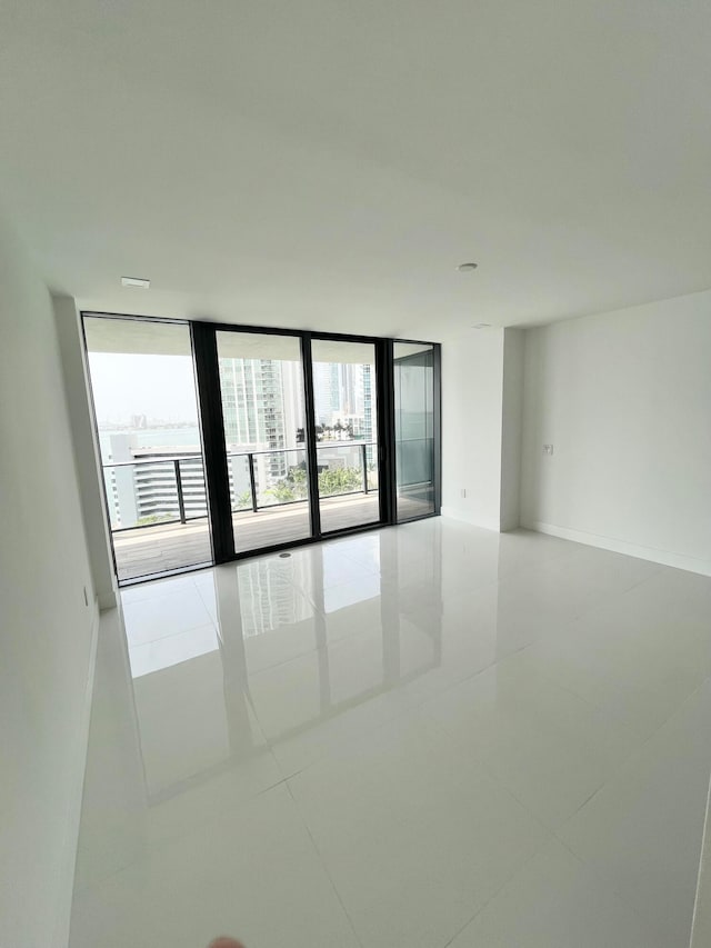 tiled spare room featuring floor to ceiling windows