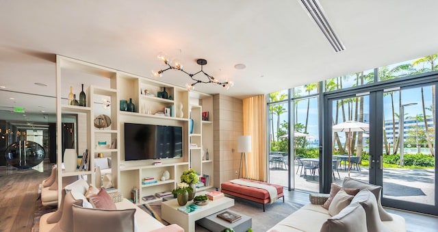 living room featuring a wall of windows, hardwood / wood-style flooring, and a chandelier