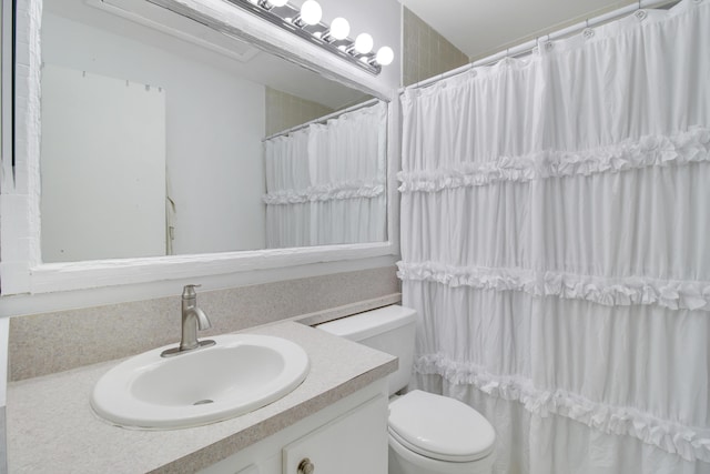 bathroom with vanity, curtained shower, and toilet