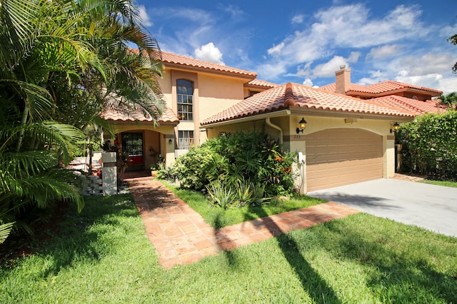 mediterranean / spanish-style house featuring a garage and a front yard