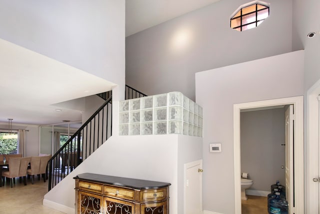 stairway featuring tile patterned flooring and a towering ceiling