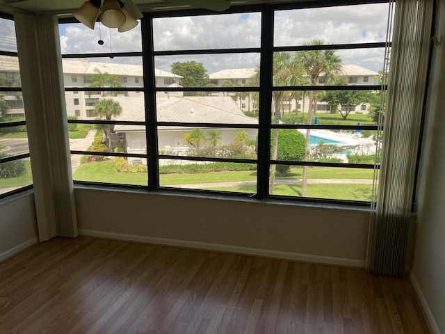 unfurnished sunroom with ceiling fan