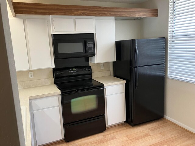 kitchen featuring black appliances, decorative backsplash, and white cabinetry