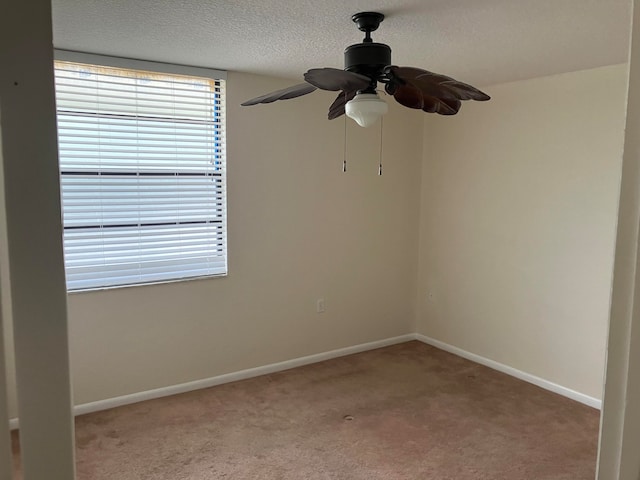 carpeted spare room featuring a textured ceiling and ceiling fan