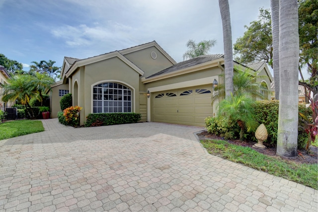 view of front of home with central air condition unit and a garage