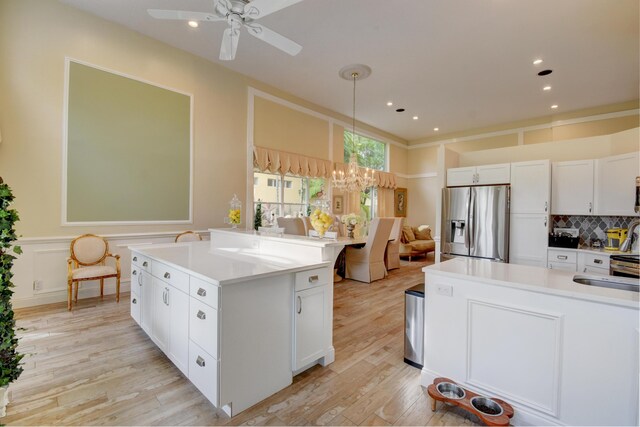 kitchen with white cabinetry, stainless steel fridge, light wood-type flooring, and ceiling fan