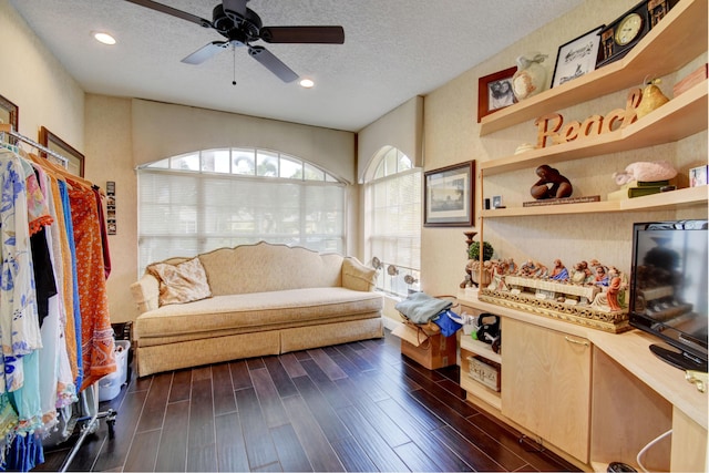 living room featuring a textured ceiling, ceiling fan, and dark hardwood / wood-style floors