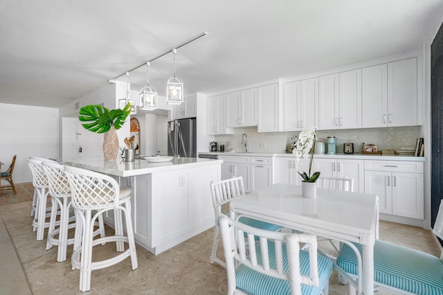 kitchen featuring white cabinetry and stainless steel fridge