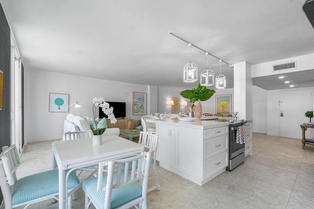 kitchen featuring hanging light fixtures, rail lighting, white cabinets, and stainless steel electric range