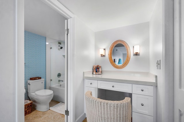 full bathroom with tiled shower / bath, vanity, and toilet