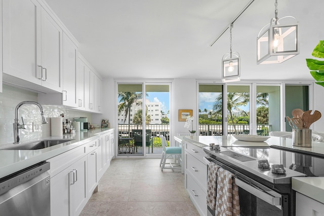 kitchen featuring tasteful backsplash, sink, white cabinets, and appliances with stainless steel finishes