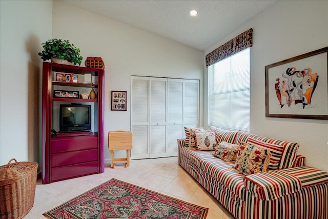 tiled living room featuring a textured ceiling and vaulted ceiling