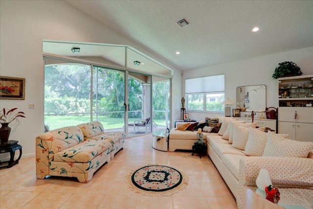 living room with light tile patterned flooring, vaulted ceiling, and a textured ceiling