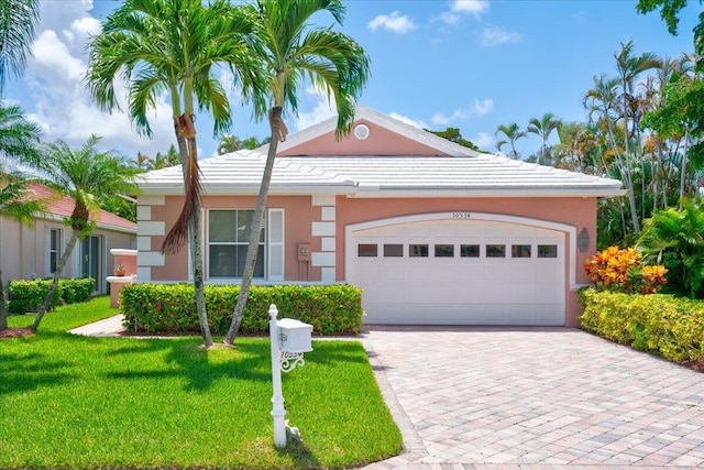 single story home featuring a garage and a front lawn