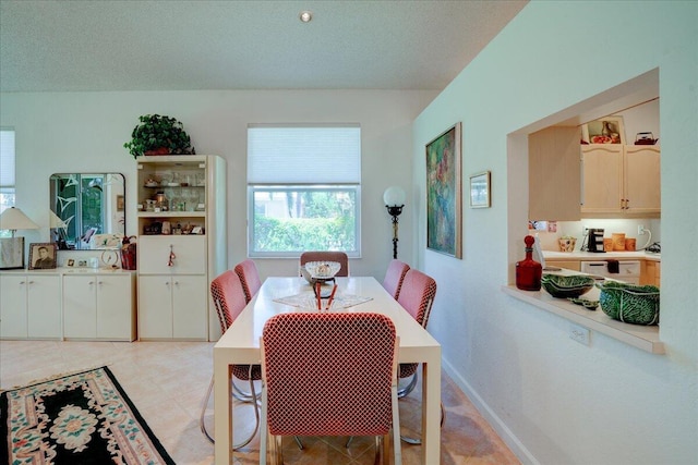 dining space with a textured ceiling and light tile patterned floors