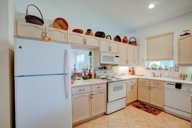 kitchen featuring light brown cabinets, white appliances, light tile patterned floors, a textured ceiling, and sink