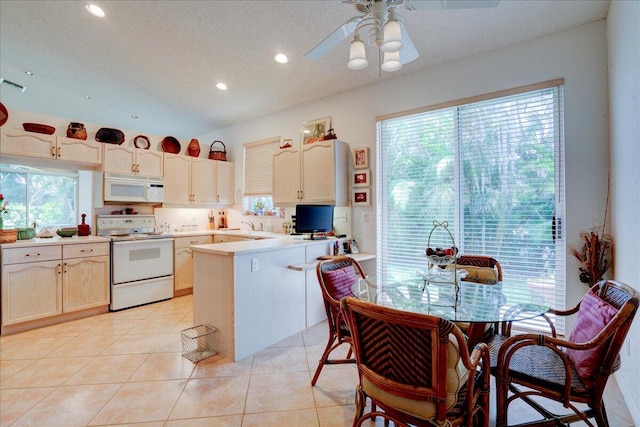 kitchen with ceiling fan, white appliances, vaulted ceiling, a textured ceiling, and light tile patterned floors