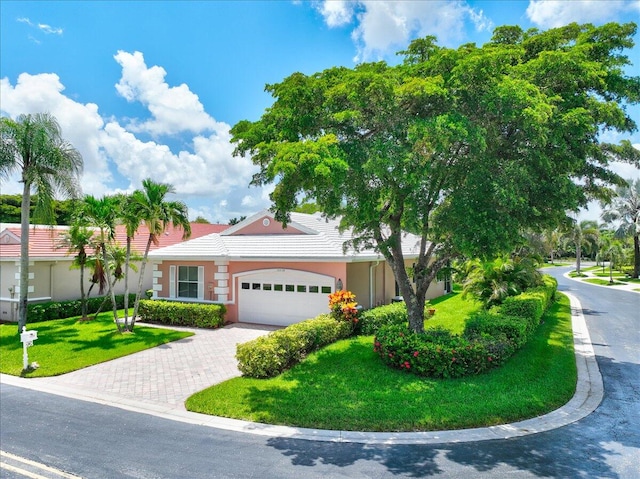 ranch-style house with a garage and a front lawn