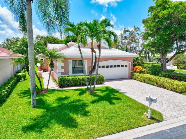 single story home featuring a garage and a front lawn