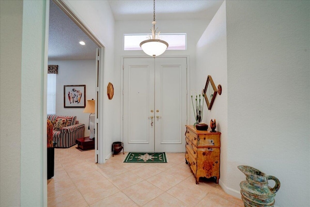 entryway featuring light tile patterned floors and a textured ceiling