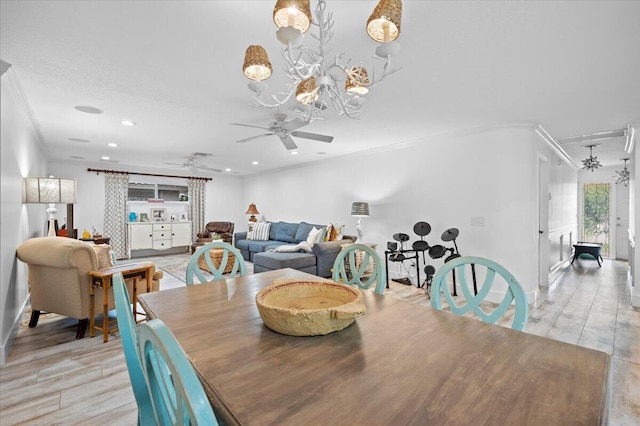 dining space featuring ceiling fan with notable chandelier and ornamental molding