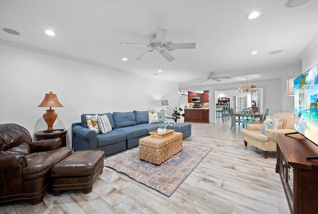 living room with ceiling fan with notable chandelier, light hardwood / wood-style floors, and crown molding