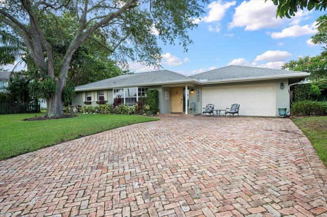 single story home featuring a garage and a front yard