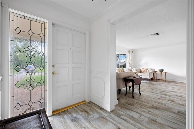 entrance foyer with a textured ceiling and light hardwood / wood-style floors