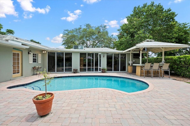 view of pool with a patio and exterior bar