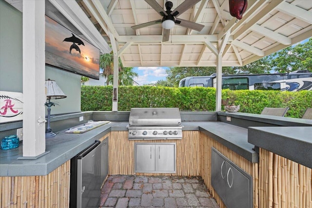 view of patio featuring ceiling fan, a grill, and exterior kitchen