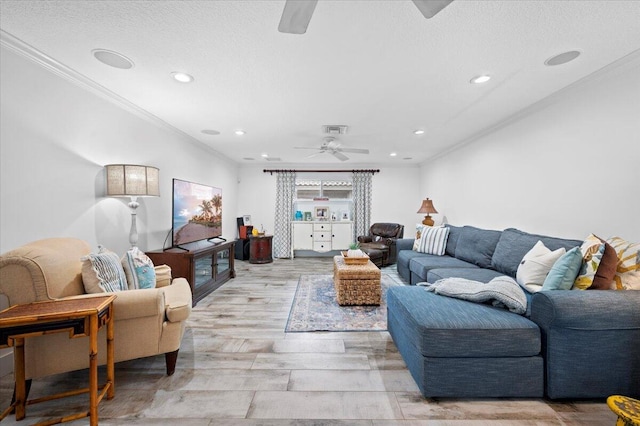 living room with light hardwood / wood-style floors, ornamental molding, and ceiling fan