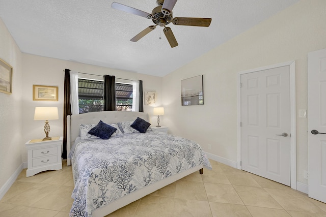 bedroom with lofted ceiling, baseboards, a textured ceiling, and light tile patterned flooring