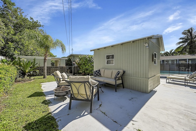 view of patio with a pool, an outdoor living space with a fire pit, and fence