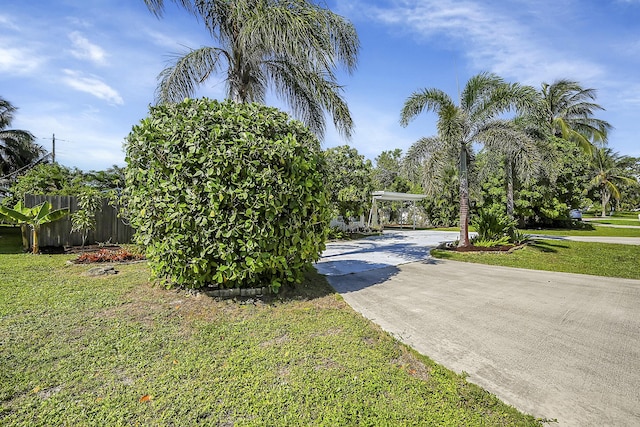 view of front of property with fence, driveway, and a front lawn