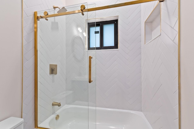 bathroom with combined bath / shower with glass door and toilet