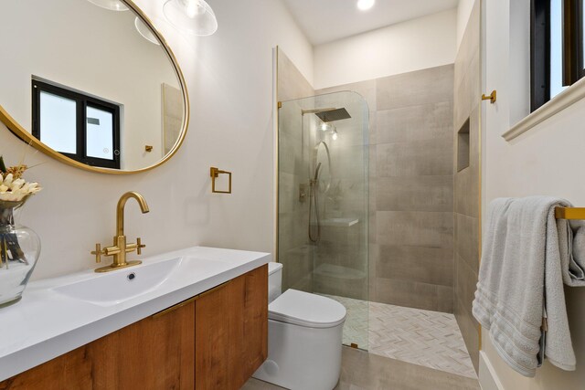 bathroom with a shower with door, toilet, and vanity