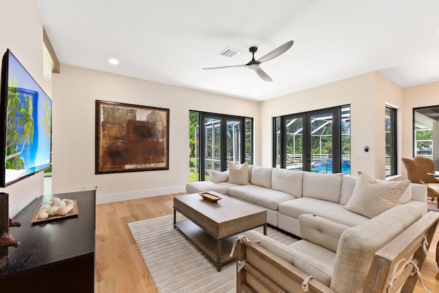 living room featuring light hardwood / wood-style flooring, french doors, and ceiling fan