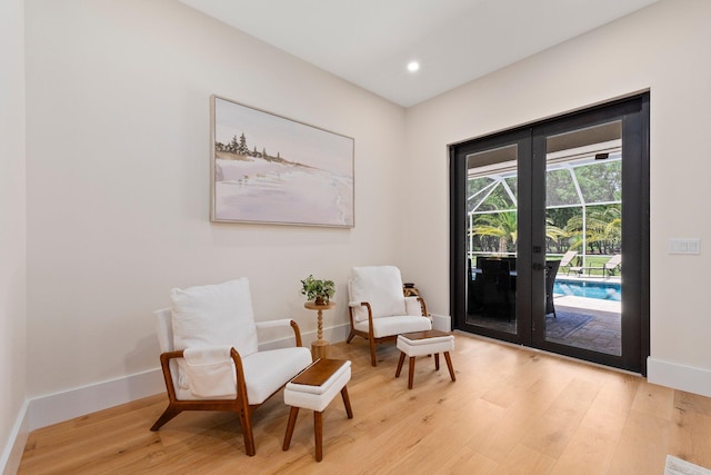 living area with french doors and light wood-type flooring