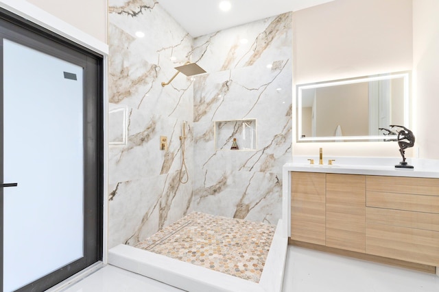 bathroom with tile patterned floors, vanity, and a tile shower