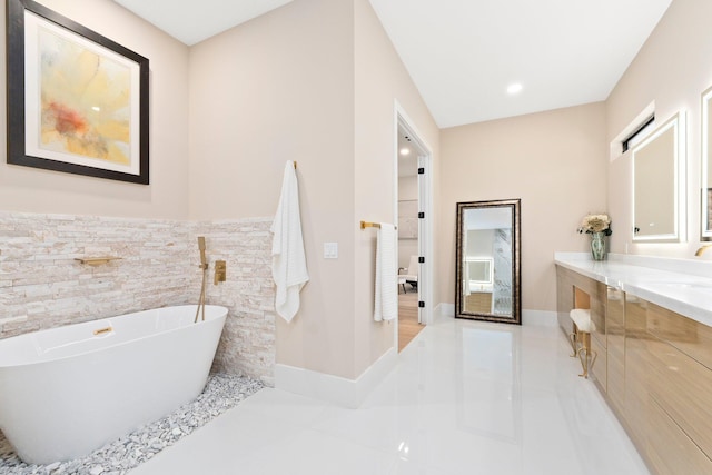 bathroom with tile patterned flooring, tile walls, a bathing tub, and vanity