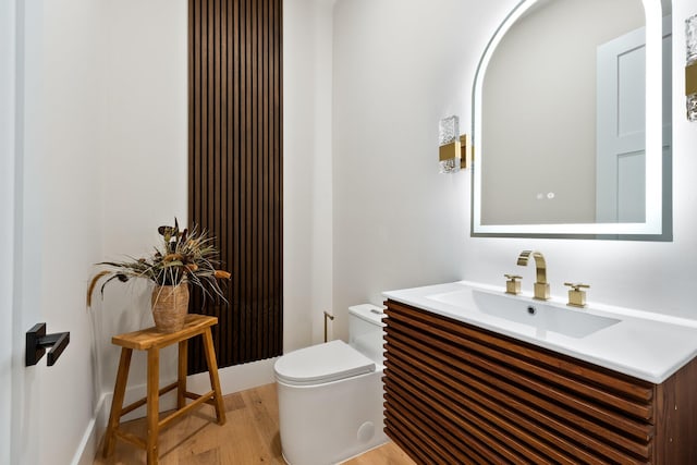 bathroom featuring wood-type flooring, toilet, and vanity