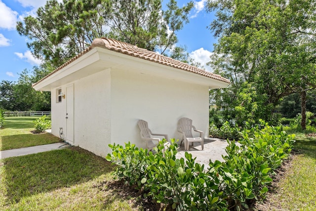 view of side of home featuring a patio area and a lawn