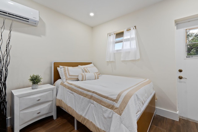 bedroom featuring a wall unit AC and dark hardwood / wood-style floors