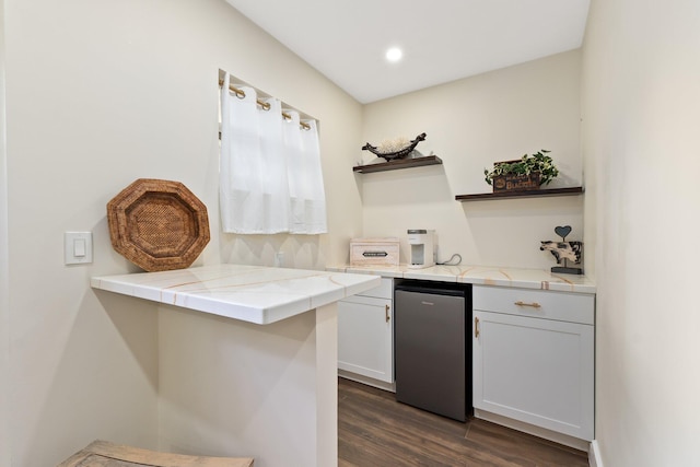 bar featuring dark wood-type flooring and fridge