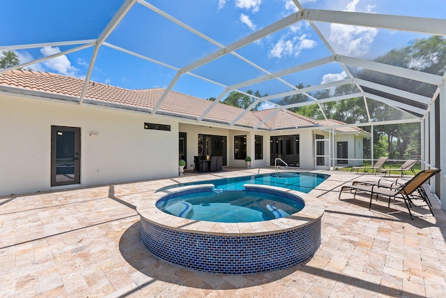 view of swimming pool featuring an in ground hot tub, a patio, and glass enclosure