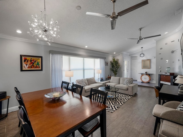 dining room with ornamental molding, a textured ceiling, ceiling fan with notable chandelier, and vaulted ceiling