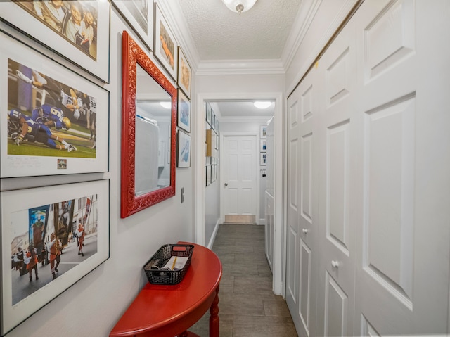 hallway with dark tile patterned floors, a textured ceiling, and ornamental molding